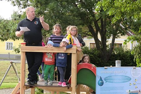 Obmann Josef Bauer mit einigen Kindern an einem der beiden neuen Spielgeräte.