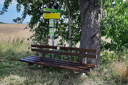 Einer der vielen Rastplätze: Bank und Wegweiser in Ritzmannshof beim Hofteich