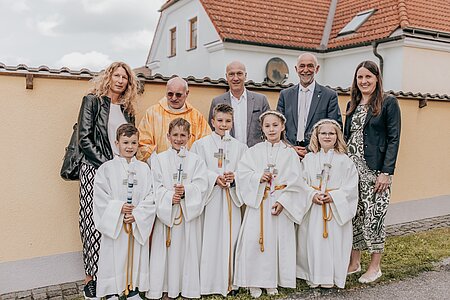Die Erstkommunionkinder Luis Hipp, Michael Holzmüller, Jakob Tatzer, Kathrin Steininger und Valtentina Meisel mit Religionslehrerin Alexandra Kugler, Pfarrer P. Daniel Gärtner, Direktor Bernhard Bachofner, Bürgermeister Josef Schaden und Klassenlehrerin Cornelia Kreutzer