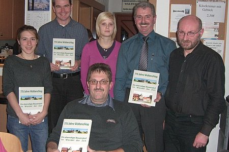 Buchpräsentation in Walterschlag -  Personen von links nach rechts: Co-Autoren Verena Gretz, Alexander Scheidl und Tanja Breiteneder; Bürgermeister Johann Hölzl und Mag. Pater Daniel Gärtner; davor der Verfasser Josef Krapfenbauer