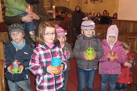 Die selbst gebastelten Laternen wurden dem Jesuskind bei der großen Strohkrippe übergeben.