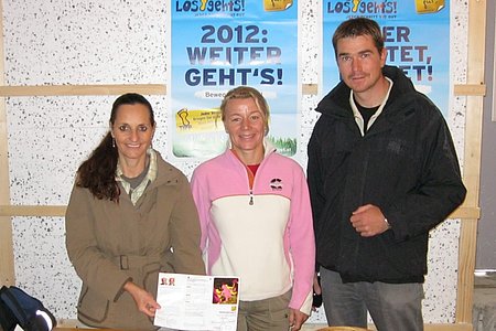 Monika Schneider, Gesundheitspädagogin Sabine Schuster und Alexander Scheidl weisen auf die interessante Wanderung der Gesunden Gemeinde hin.