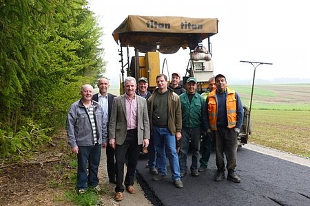 Gf.GR Josef Koppensteiner, Vbgm. Josef Schaden, Bgm. Johann Hölzl und Güterwegobmann Martin Wally mit der Baufirma bei den Asphaltierungsarbeiten am neuen Güterweg