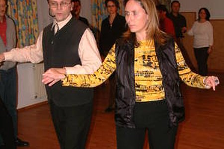 Der Tanzlehrer zeigt mit seiner Partnerin die richtige Haltung bei einer Figur